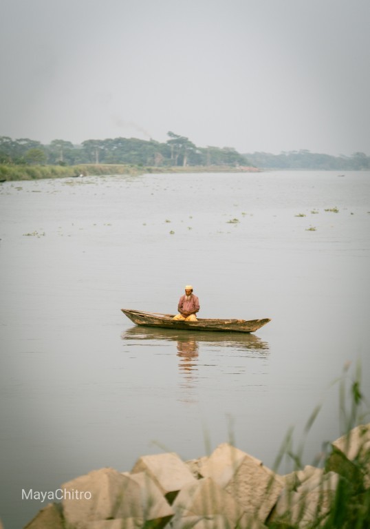Lone Boatman on River
